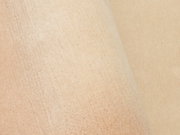 Nahaufnahme eines beigen Wollteppichs mit weicher Textur, von oben betrachtet.