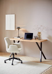 Moderner Schreibtisch mit Holzplatte und schwarzen Metallbeinen, seitliche Perspektive, dekoriert mit Laptop, Lampe und Vase.