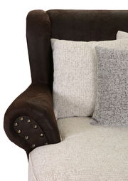 Nahaufnahme eines Megaohrensessels mit brauner Armlehne und beigen Kissen, seitliche Perspektive