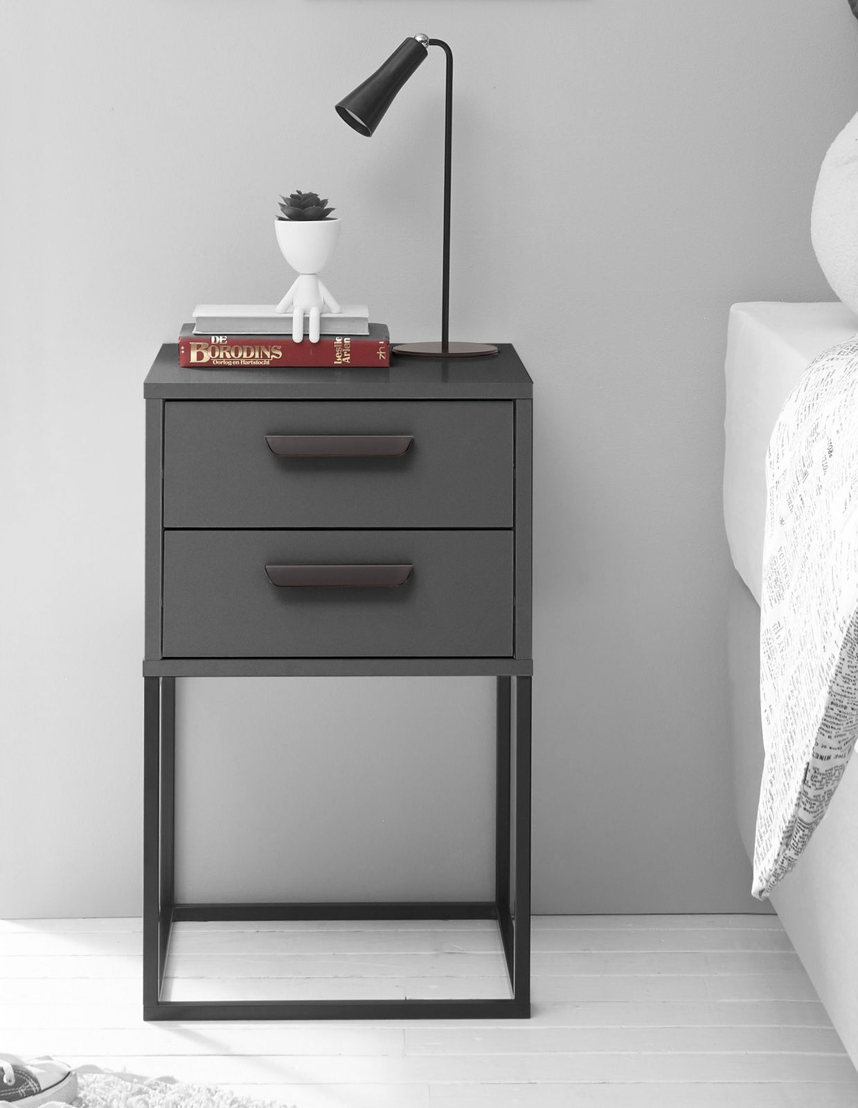 Moderne Nachtkommode mit zwei Schubladen, schwarzem Metallrahmen und minimalistischer Dekoration, seitliche Perspektive