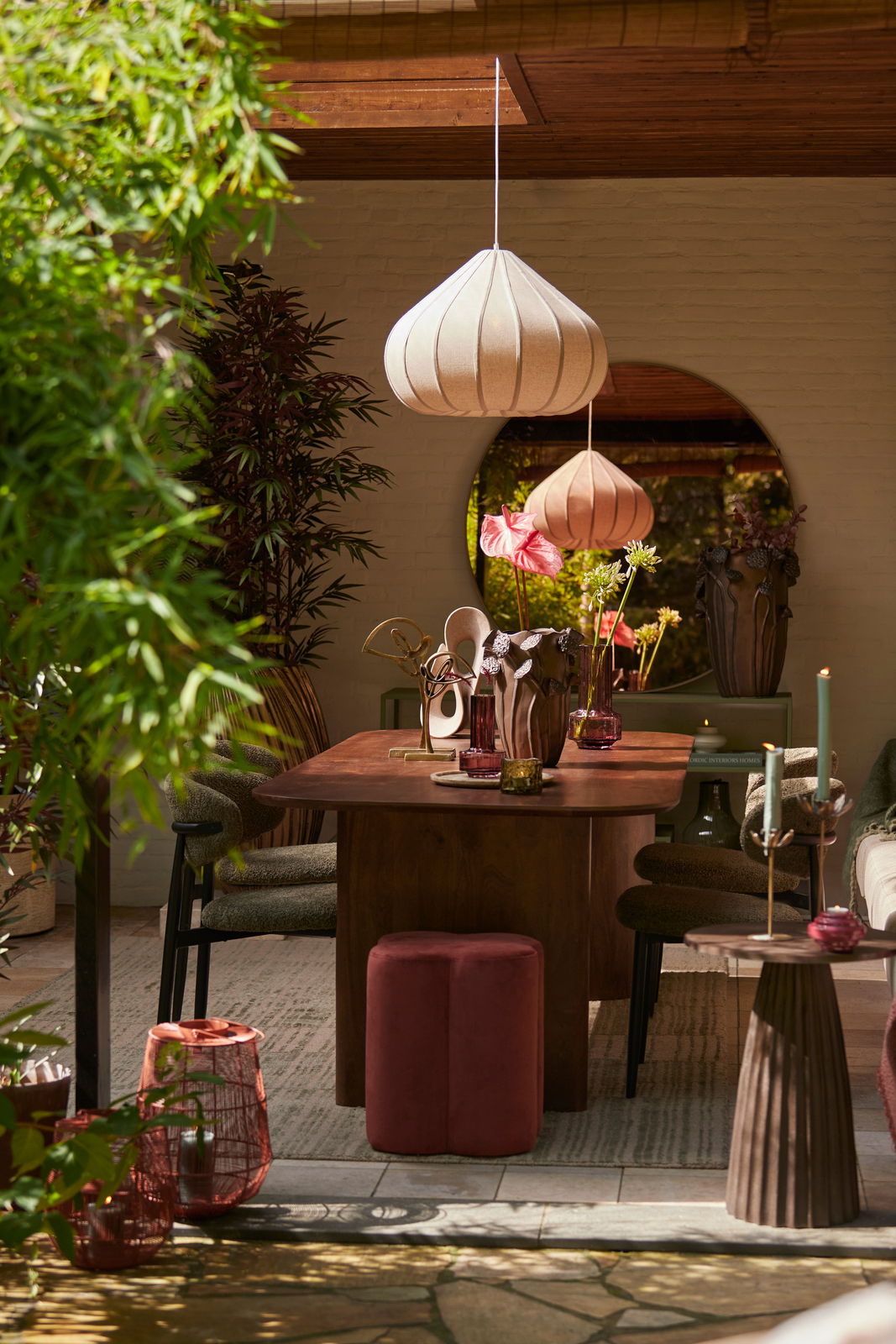 Roter Sitzpuff NALANI in einem stilvoll eingerichteten Raum, frontal vor einem Holztisch platziert.