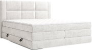 Lichtgrijs gestoffeerd boxspringbed met gewatteerd hoofdbord en wit matras, schuin van voren gefotografeerd op witte achtergrond