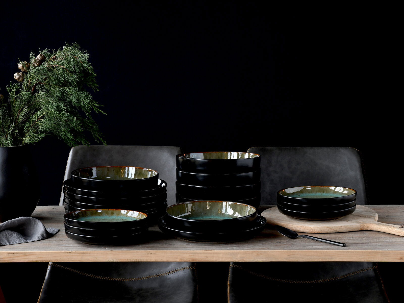 Tellerset 18-tlg. Green auf einem Tisch, seitliche Perspektive, mit dekorativen Elementen im Hintergrund