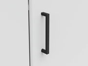 Nahaufnahme eines schwarzen, modernen Griffs an einer weißen Eckkommode, seitliche Perspektive