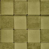 Nahaufnahme eines grünen, gewebten Stoffmusters, das die Oberfläche eines Hockers mit Stauraum zeigt.