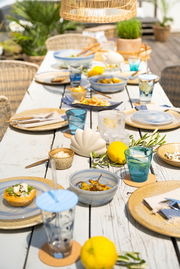 Ein stilvoll gedeckter Tisch im Freien mit dem Tischlicht SALERNO 12cm in der Mitte, umgeben von Geschirr, Gläsern und Zitronen, aus der Vogelperspektive fotografiert.