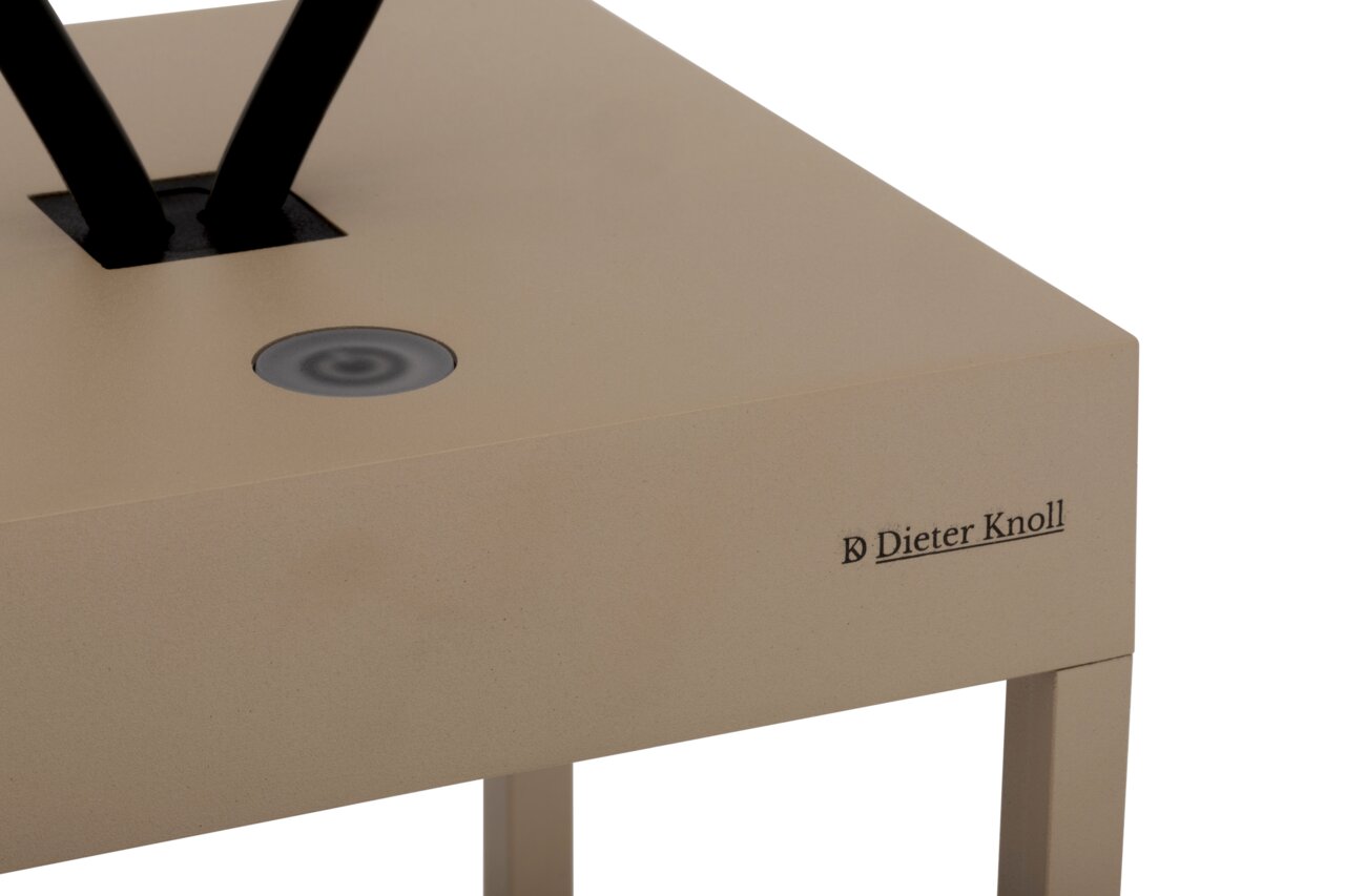 Close-up van een draagbare tafellamp van Dieter Knoll in beige met een zwarte aanraakschakelaar aan de bovenkant.