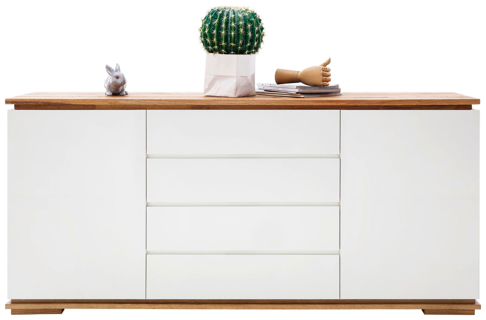 Frontale Ansicht eines modernen Sideboards mit weißer Front und Holzoberfläche, dekoriert mit einem Kaktus, einer Holzhand und einem kleinen Hasen.