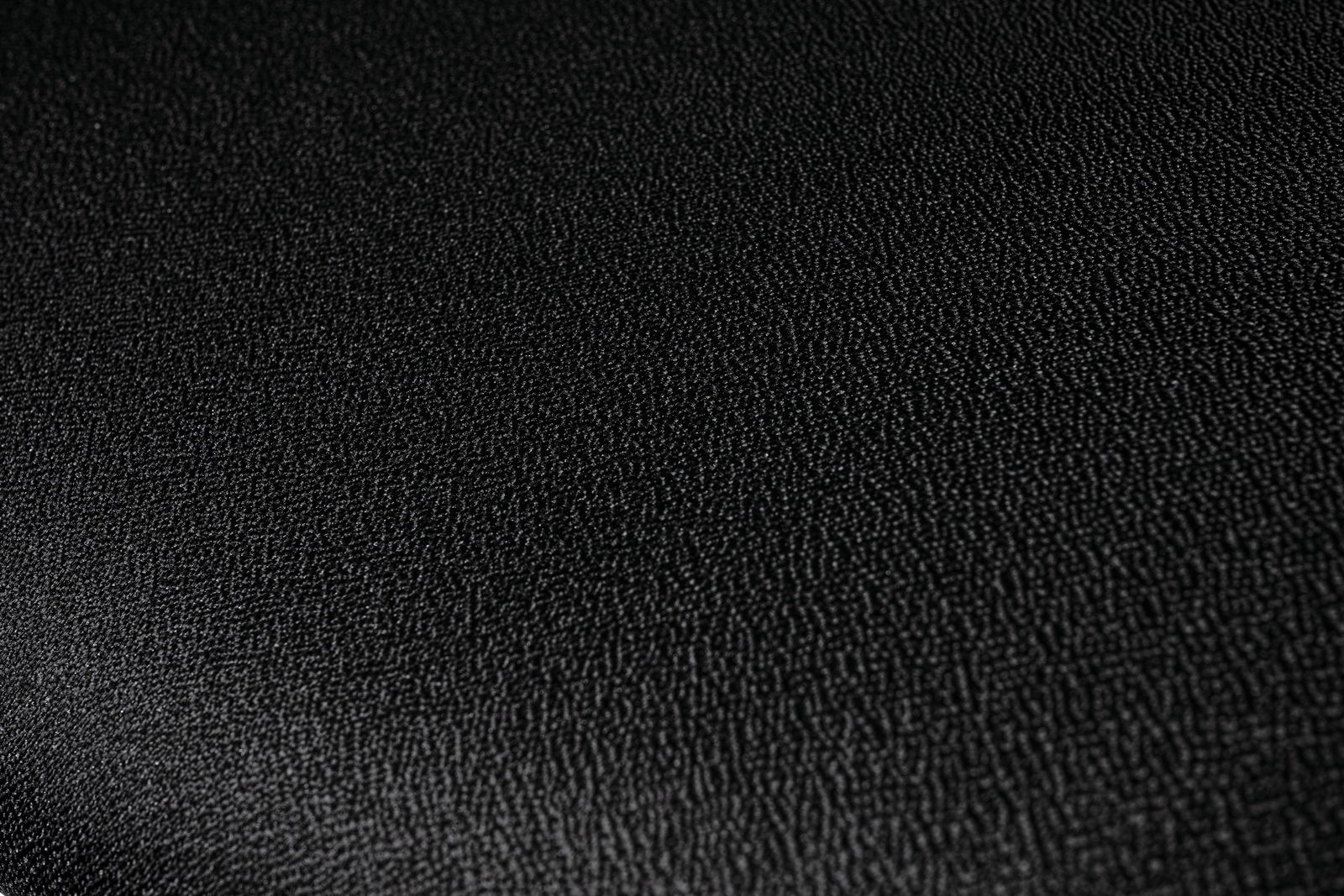 Nahaufnahme der schwarzen, strukturierten Oberfläche eines Besucherstuhls.