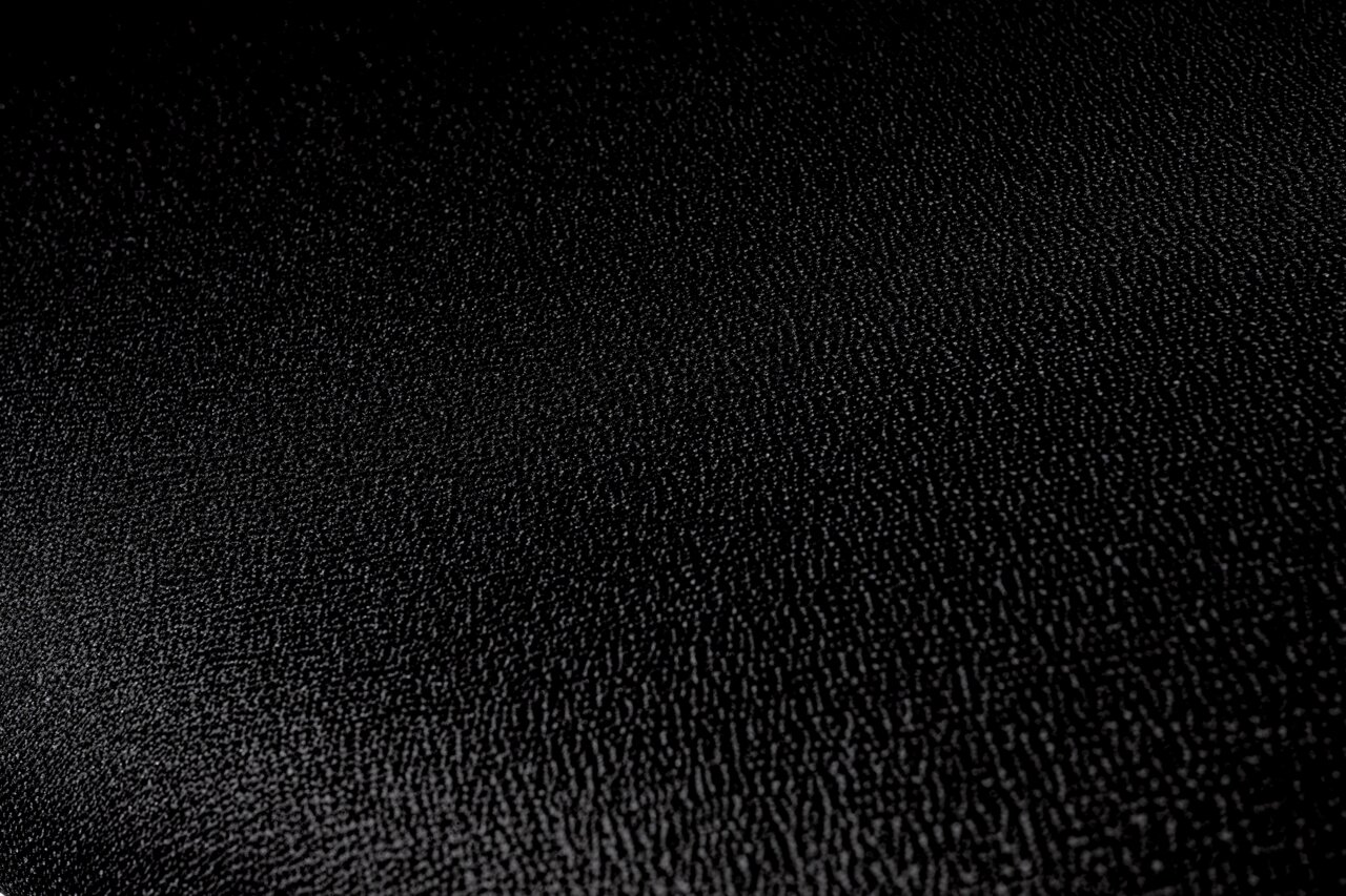 Nahaufnahme der schwarzen, strukturierten Oberfläche eines Besucherstuhls.