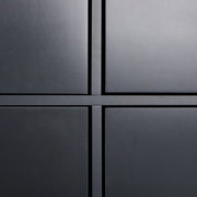 Nahaufnahme eines modernen, schwarzen Highboards mit klaren Linien und minimalistischer Gestaltung, frontal betrachtet.