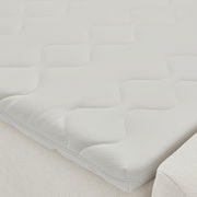 Nahaufnahme einer weißen Matratze mit wellenförmigem Muster auf einem Boxbett.