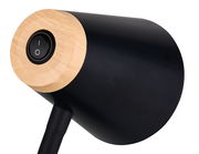 Nahaufnahme einer modernen Tischleuchte mit schwarzem Lampenschirm und Holzdetails, seitliche Perspektive.