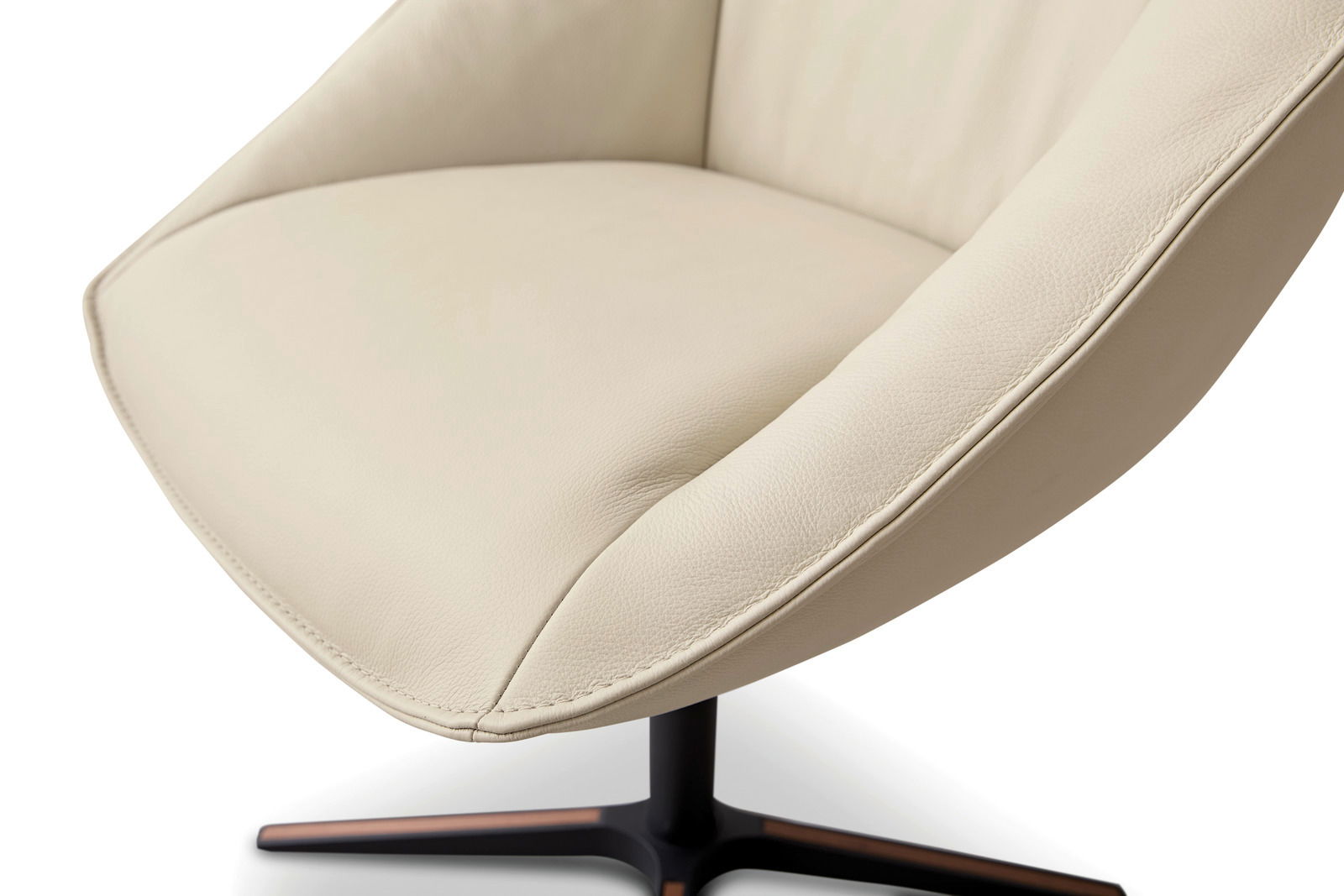 Nahaufnahme eines beigen Armlehnstuhls mit geschwungenem Design und schwarzem Metallfuß, seitliche Perspektive