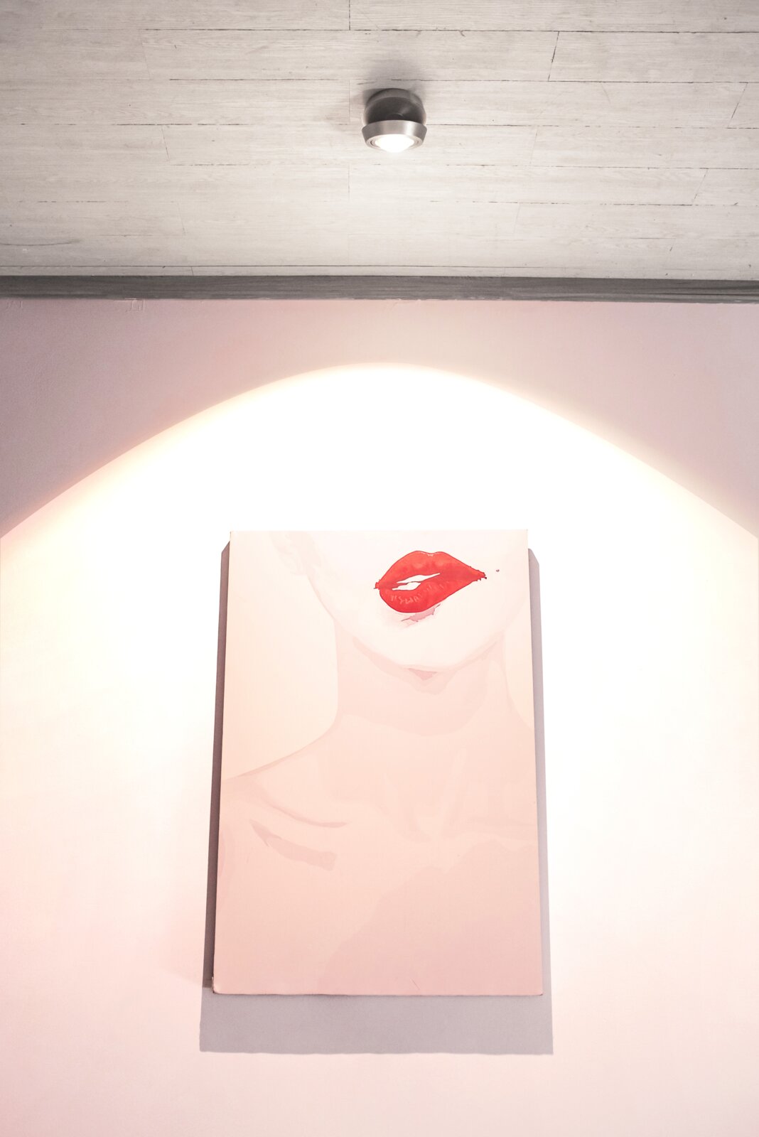 Megatron LED-Deckenleuchte SOLO MOVIMENTO LED Aufbauleuchte an der Decke, beleuchtet ein Kunstwerk mit roten Lippen aus der Frontalperspektive