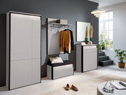 Moderne Garderobeneinrichtung in einem hellen Raum mit großem Fenster, bestehend aus einem XL-Garderobenschrank, einer Garderobenbank mit Kissen, einem Garderobenpaneel mit Kleiderstange und einem Sideboard, seitliche Perspektive.