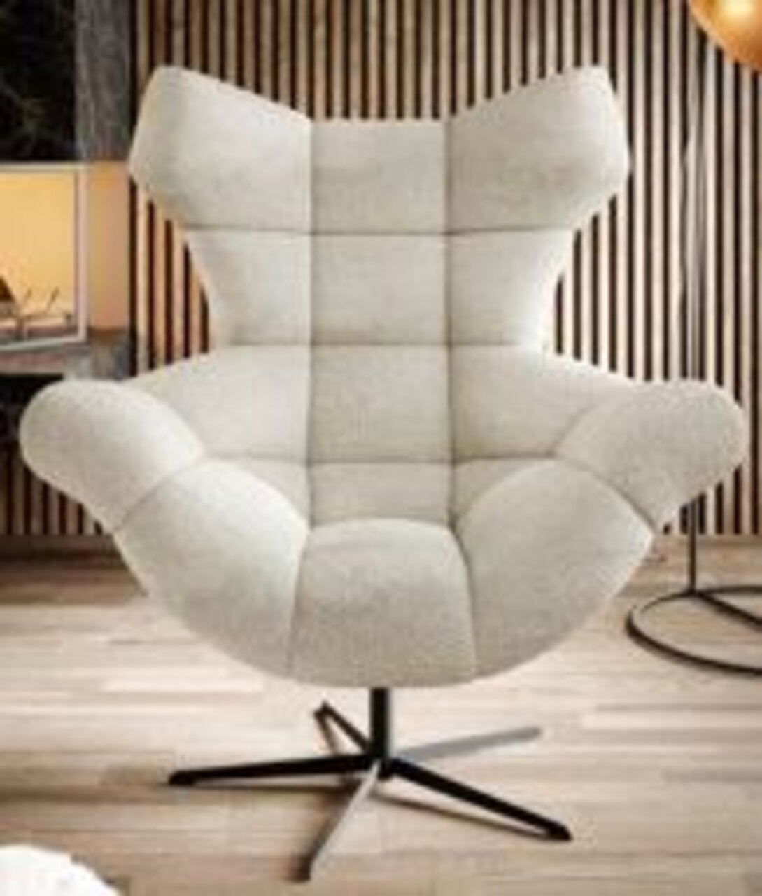 Moderne fauteuil met lichtgrijze stoffen bekleding en een opvallend ontwerp, gefotografeerd van voren.