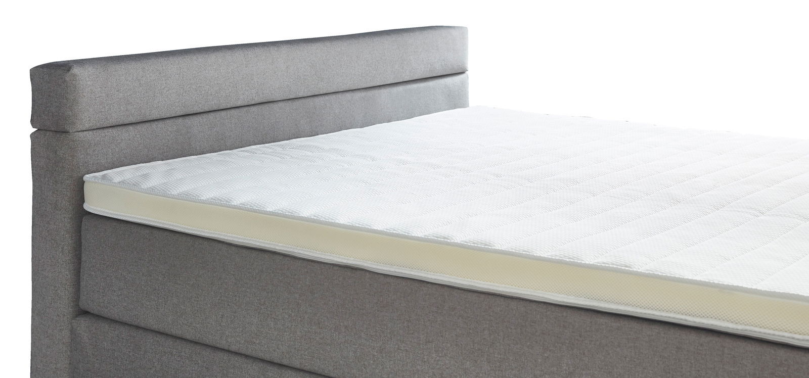 Seitliche Ansicht eines grauen Boxspringbetts mit weißer Matratze
