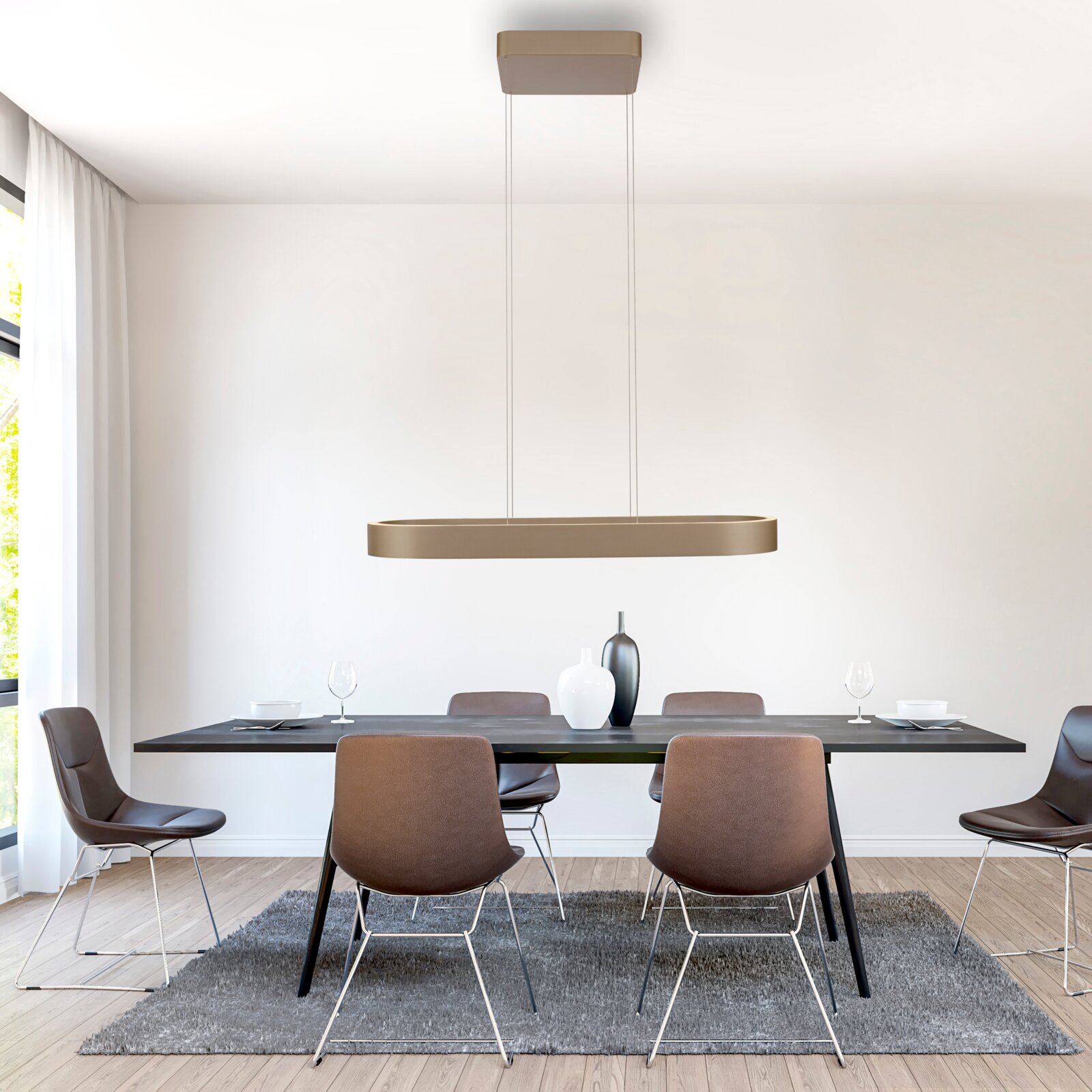 Moderne, längliche LED-Pendelleuchte in Gold/Champagner über einem Esstisch, frontale Perspektive im hellen Esszimmer