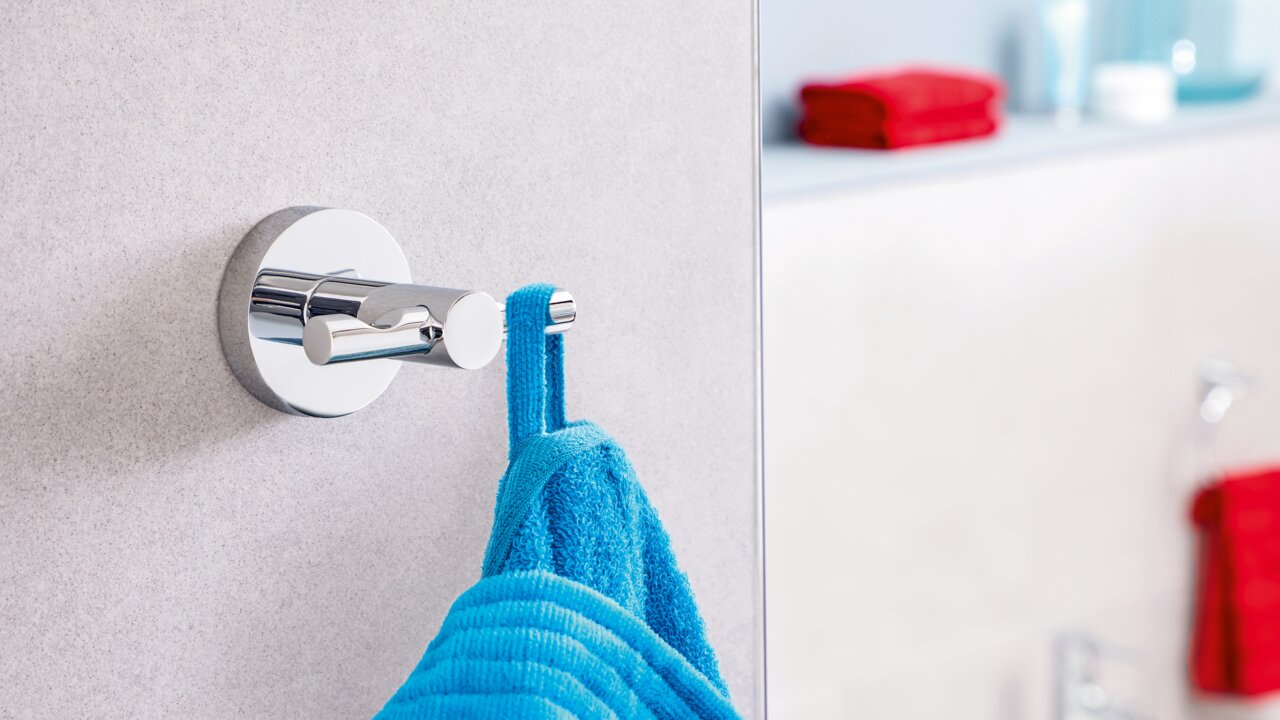Tesa Badjashaak EXXCELLENT Wandhaken aus Chrom mit blauem Bademantel, seitliche Perspektive