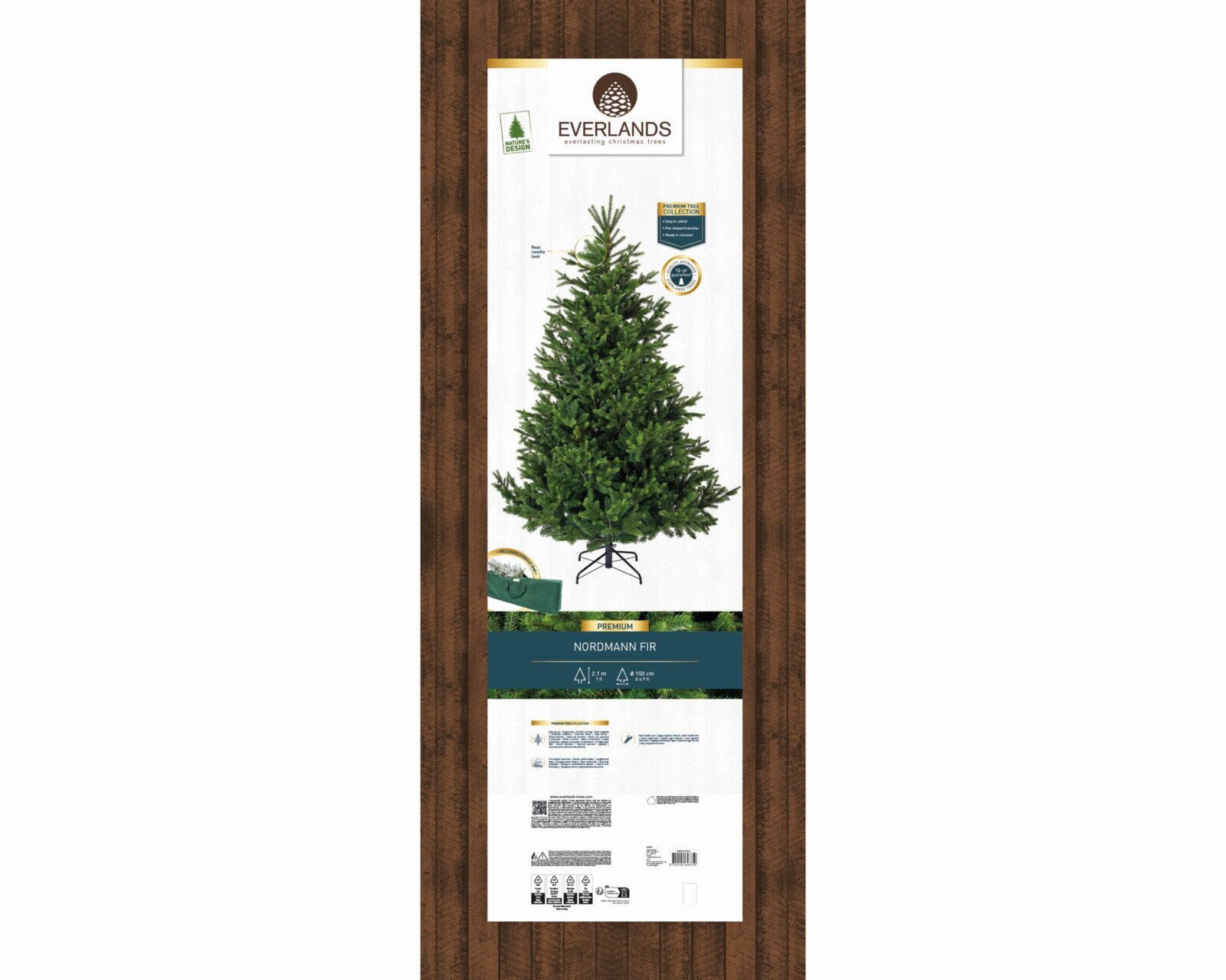 Everlands Premium Nordmanntanne als künstlicher Weihnachtsbaum mit naturgetreuer Benadelung und Metallständer, 2,1 m hoch und ca. 150 cm breit, in frontaler Gesamtansicht auf der Verpackung