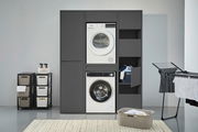 Doppel-Waschmaschinenschrank in dunklem Design mit integrierter Waschmaschine und Trockner, seitlich offene Regale und geschlossene Schränke, frontal betrachtet.