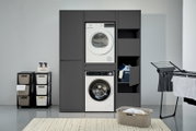 Doppel-Waschmaschinenschrank in dunklem Design mit integrierter Waschmaschine und Trockner, seitlich offene Regale und geschlossene Schränke, frontal betrachtet.