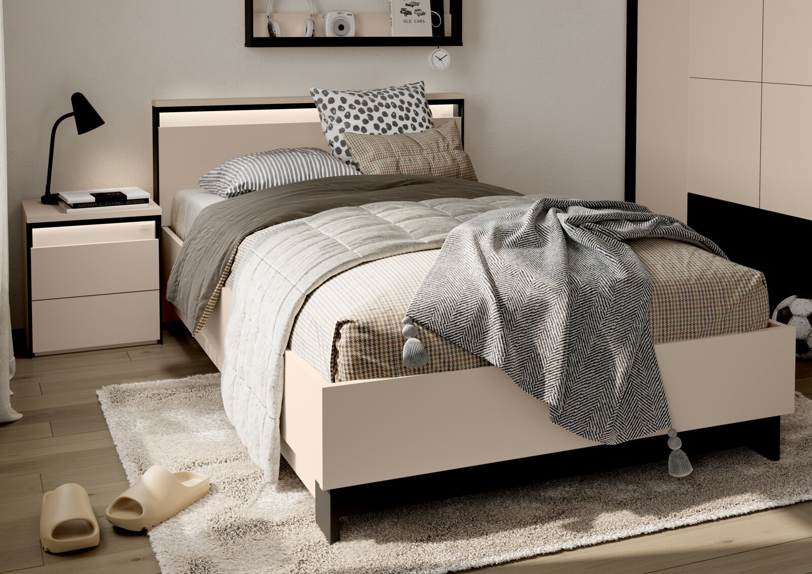 Modernes Einzelbett in Beige mit schwarzem Rahmen und integriertem LED-Licht am Kopfteil, dekoriert mit grauer Bettwäsche, gemusterten Kissen und Decke Perspektive: frontale Dreiviertelansicht von leicht oben.