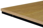Nahaufnahme einer Tischkante aus Holz mit schwarzem Metallrahmen, perspektivisch von der Seite aufgenommen.