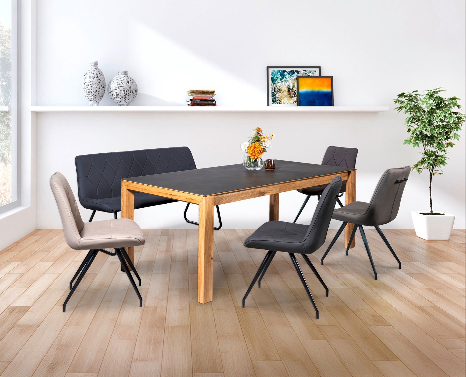 Moderner Essbereich mit einem großen Esstisch aus Holz und dunkler Tischplatte, umgeben von stilvollen Stühlen und einer Bank, mit Blick auf einen sonnigen Garten durch große Fenster.