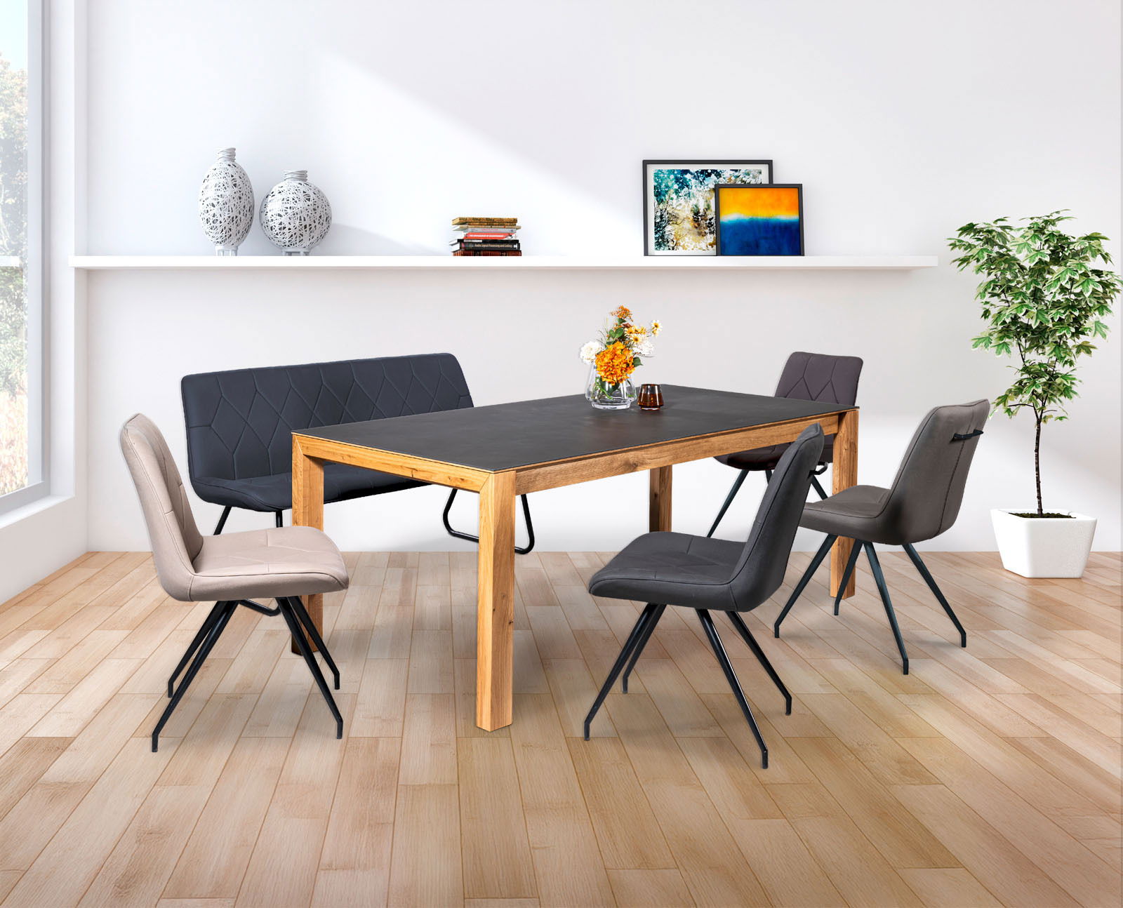 Linea Natura Esstisch BELLAGIO Moderner Essbereich mit einem großen Esstisch aus Holz und dunkler Tischplatte, umgeben von stilvollen Stühlen und einer Bank, mit Blick auf einen sonnigen Garten durch große Fenster.