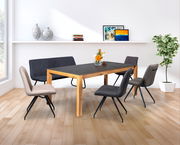 Moderner Essbereich mit einem großen Esstisch aus Holz und dunkler Tischplatte, umgeben von stilvollen Stühlen und einer Bank, mit Blick auf einen sonnigen Garten durch große Fenster.