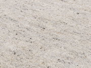 Nahaufnahme eines cremefarbenen Wollteppichs mit feiner Textur und dezenten Farbakzenten.