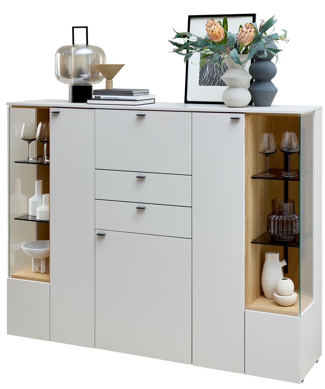 Modernes Highboard in Weiß mit Glasvitrinen, dekoriert mit Vasen, Gläsern und Büchern, aus frontaler Perspektive.