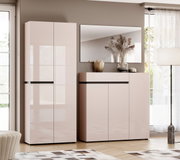 Frontansicht eines modernen, hochglänzenden Flurmöbel-Sets in Rosé/Beige mit hohem Schrank und Sideboard, darüber ein Wandspiegel, dekoriert mit Vase und Trockenblumen in einem hellen Wohnraum