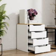 Moderne weiße Kommode mit vier geöffneten Schubladen und Holzplatte, dekoriert mit Büchern und Hortensienvase, im schrägen Frontblick in hellem Wohnraum