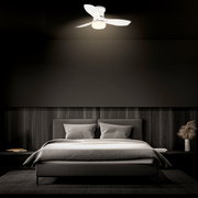 Weißer Deckenventilator mit integrierter LED-Deckenleuchte über einem Bett im Schlafzimmer, Perspektive: leicht von unten nach oben auf den Ventilator