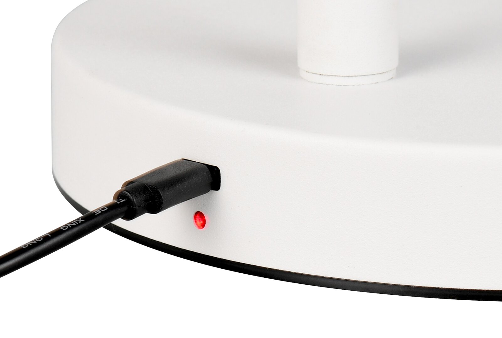 Nahaufnahme der Ladebuchse einer weißen Akku-Stehleuchte mit eingestecktem Kabel und leuchtender roter LED.