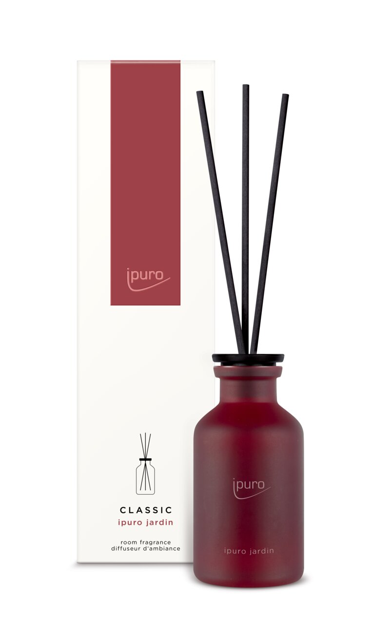 Raumduft Classic jardin in einer roten Flasche mit schwarzen Stäbchen, frontal abgebildet vor der Verpackung.