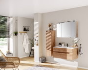 Moderne houten badkamerkast, links naast een wastafelonderkast en een spiegelkast, gefotografeerd vanuit zijaanzicht.