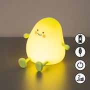 Niedliche Akku-Nachtleuchte in Form einer gelben Mango mit Gesicht, Armen und Beinen, von vorne betrachtet.