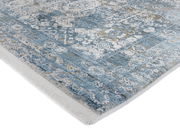 Designer Teppich in Blau- und Grautönen mit detailliertem Muster, perspektivisch von der Seite aufgenommen.