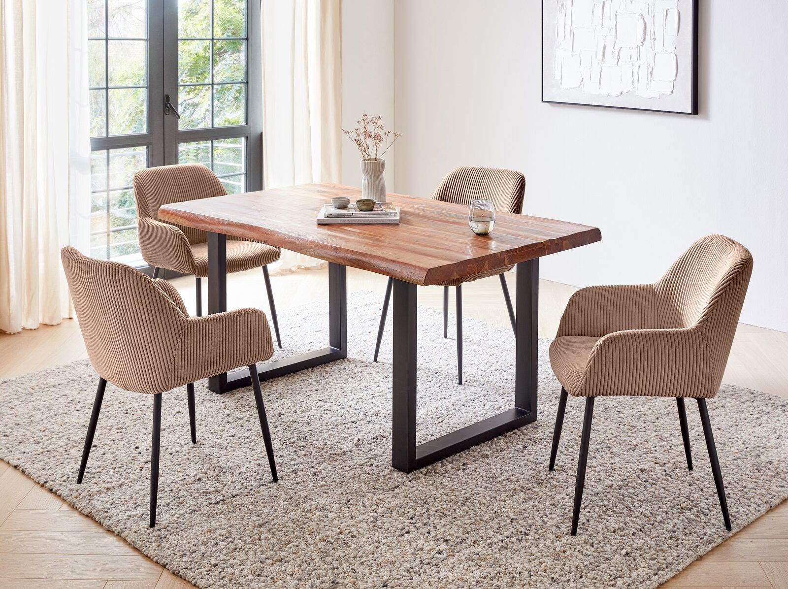 Esszimmer mit einem Holztisch und vier Armlehnstühlen in einem modernen, hellen Raum. Perspektive von schräg oben.