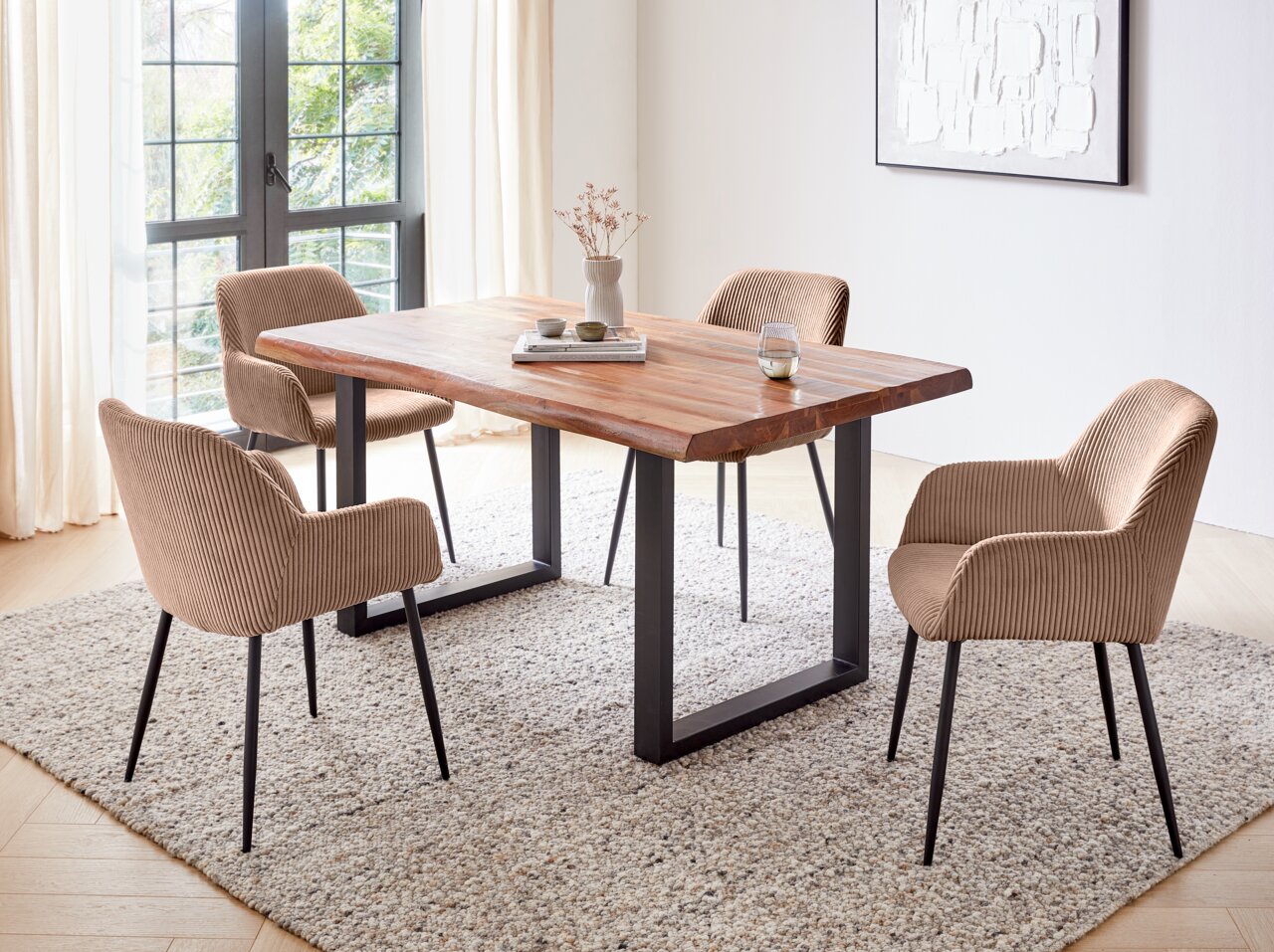 Esszimmer mit einem Holztisch und vier Armlehnstühlen in einem modernen, hellen Raum. Perspektive von schräg oben.