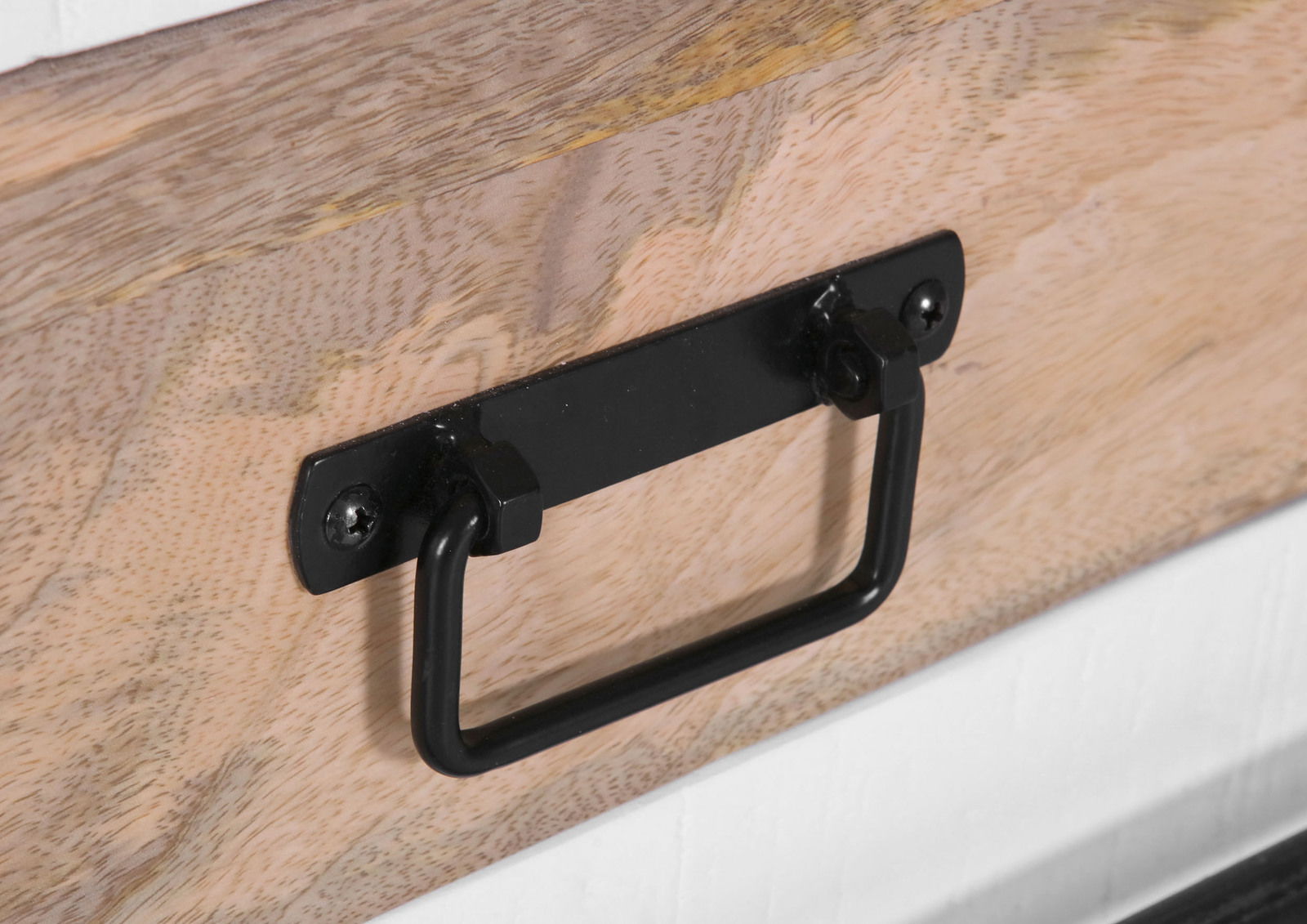 Nahaufnahme eines schwarzen Metallgriffs an einem hölzernen Sideboard, seitliche Perspektive