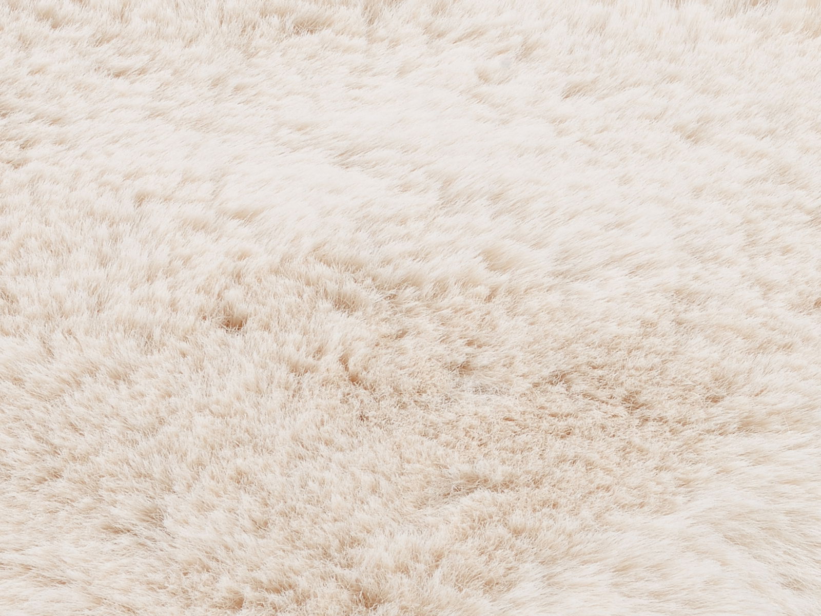 Nahaufnahme eines weichen, flauschigen Fellteppichs in cremeweißer Farbe.