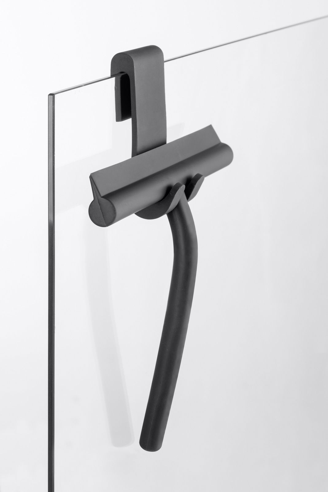 Schwarzer Badezimmerwischer aus Silikon, aufgehängt an einer Glaswand, seitliche Perspektive