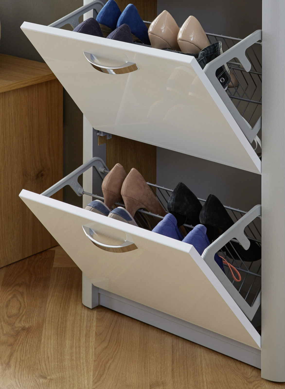 Schuhschrank mit zwei offenen Klappen, gefüllt mit verschiedenen Schuhen, aus seitlicher Perspektive fotografiert.