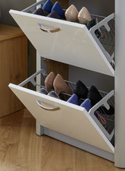 Schuhschrank mit zwei offenen Klappen, gefüllt mit verschiedenen Schuhen, aus seitlicher Perspektive fotografiert.