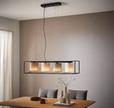 Moderne Hängeleuchte mit vier zylindrischen Lampenschirmen in einem rechteckigen Rahmen, von der Decke hängend über einem Esstisch, seitliche Perspektive.